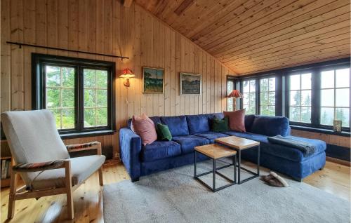 a living room with a blue couch and a chair at Amazing Home In Sjusjøen With Sauna in Sjusjøen
