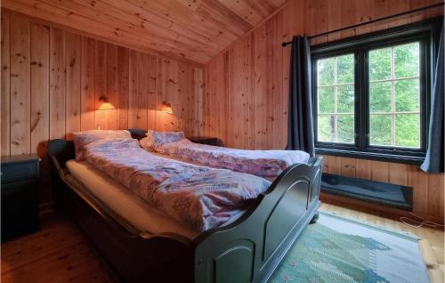 a bedroom with a bed in a room with wooden walls at Stunning Home In Sjusjen With House A Mountain View in Sjusjøen