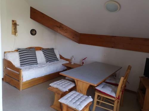 a bedroom with a bed and a table and chairs at Appartement cosy dans chalet vue Montagne in Le Dévoluy