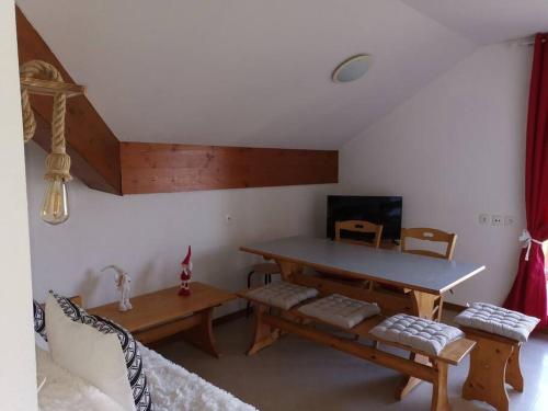 a living room with a table and a couch at Appartement cosy dans chalet vue Montagne in Le Dévoluy