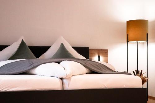 a bed with a blanket on top of it at Imi Appartement in Eben im Pongau