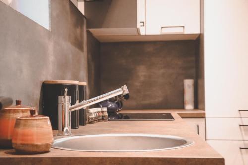 uma bancada de cozinha com um lavatório e um lavatório em Imi Appartement em Eben im Pongau