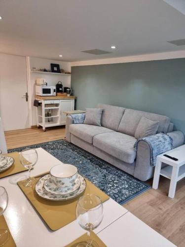 a living room with a couch and a table with wine glasses at Appartament Bel Air in Cherbourg en Cotentin