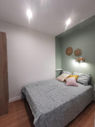 une chambre avec un grand lit avec des oreillers roses dans l'établissement APPARTEMENTS ACCES PRIVE PLAGE DE LA BERGERIE, à Hyères