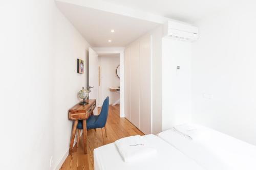 a bedroom with two beds and a desk and a chair at FLH Mouraria Blue Design with Parking & Pool in Lisbon