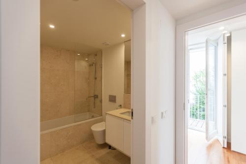 a bathroom with a tub and a toilet and a sink at FLH Mouraria Blue Design with Parking & Pool in Lisbon