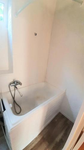 a white bathroom with a tub in the corner at Guest House - Гостевой частный дом in Dnipro