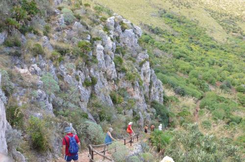 a group of people walking up a mountain at Villa delle Stelle in Scopello