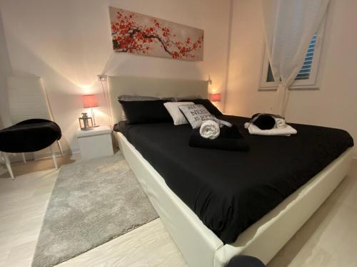 una camera da letto con un letto con lenzuola bianche e nere di Dependance a Tertenìa