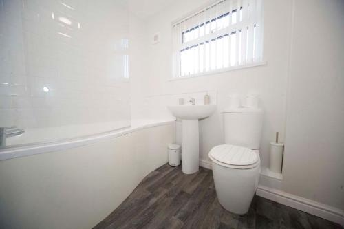 a white bathroom with a toilet and a sink at Marlborough Cottage in Stockton-on-Tees