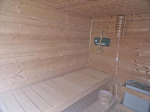 een houten sauna met een bank en een emmer bij FeWo Schwerin-Zippendorf mit Sauna und Strandnähe, 4 km bis zur City in Ostorfer Hals