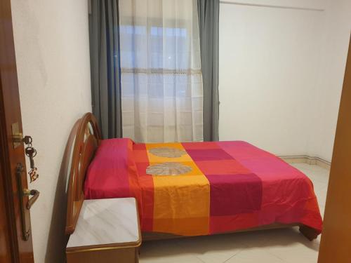 a colorful bed in a room with a window at Hermosa Habitación A individual. Getafe centro.Cerca del metro y Renfe in Getafe
