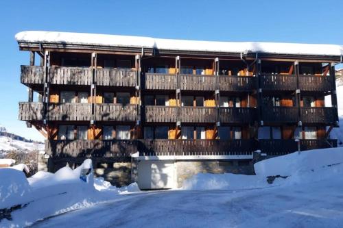 un bâtiment dans la neige recouvert de neige dans l'établissement Lune D'Argent Appartement avec vue sur la montagne, à Megève