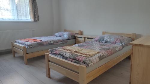 a room with two beds and a table at Privat Liska in Liptovský Mikuláš