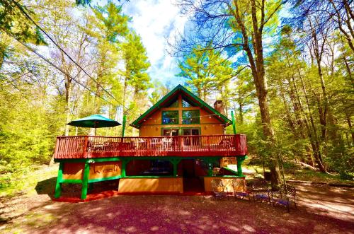 una casa con un ampio ponte nel bosco di ⛰⛵️⛱Mt. Maplewood Lodge❤️Seasonal Specials ☆Poconos☆Cabin☆Hot⛷Tub☆Game Room☆ a Pocono Pines