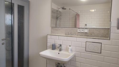 een witte badkamer met een wastafel en een spiegel bij Privat Liska in Liptovský Mikuláš