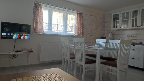 a kitchen with a table and chairs and a tv at Privat Liska in Liptovský Mikuláš