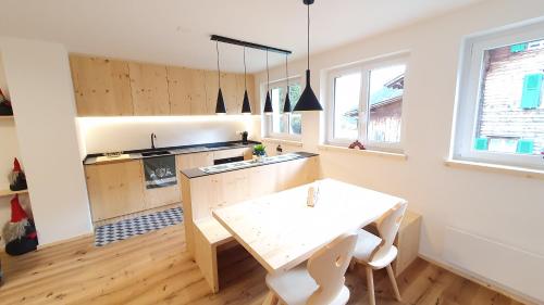 a kitchen with a white table and a table and chairs at Yeti Lodge in Sedrun