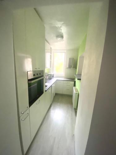 Una pequeña cocina con gabinetes blancos y una ventana. en CASA DIEGO, en Bucarest