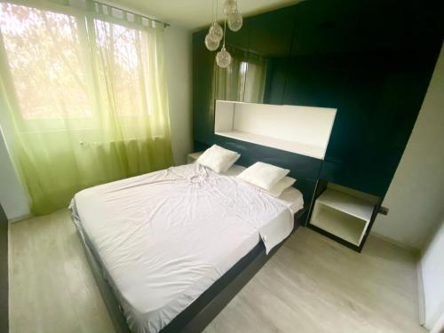 a bedroom with a white bed and a green wall at CASA DIEGO in Bucharest