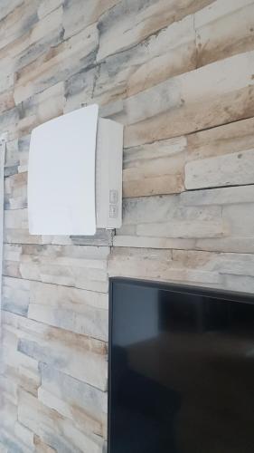 a television and a white box on a brick wall at Ferienwohnung Sonne 