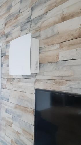 a television and a white box on a brick wall at Ferienwohnung Sonne in Stahlhofen
