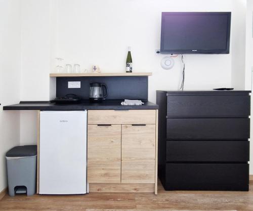 a kitchen with a refrigerator and a tv on a wall at Apartmány Minoris in Liptovský Mikuláš