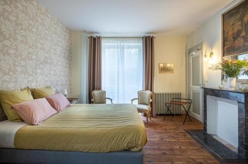 a hotel room with a bed and a fireplace at Château de Charnizay in Charnizay