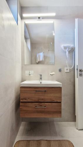 a bathroom with a sink and a mirror at Apartmány Minoris in Liptovský Mikuláš