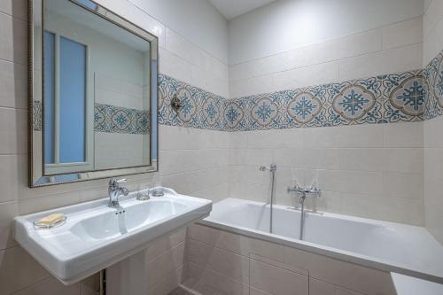 a bathroom with a sink and a tub and a mirror at Château de Charnizay in Charnizay