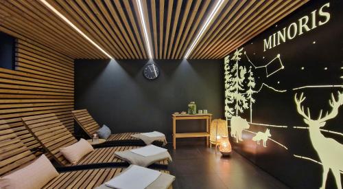 a room with benches and a table and a clock on the wall at Apartmány Minoris in Liptovský Mikuláš