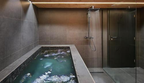 a bathroom with a bath tub with a shower at Apartmány Minoris in Liptovský Mikuláš