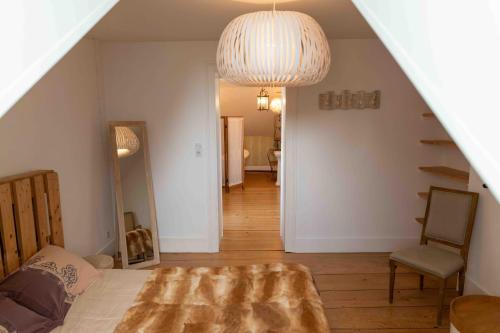 a living room with a bed and a pendant light at Le Parc du Magnolia in Montbéliard