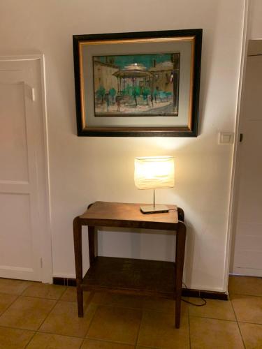 a lamp on a table with a picture on the wall at Le Gîte de Buffetières in Saint-Romain-de-Popey