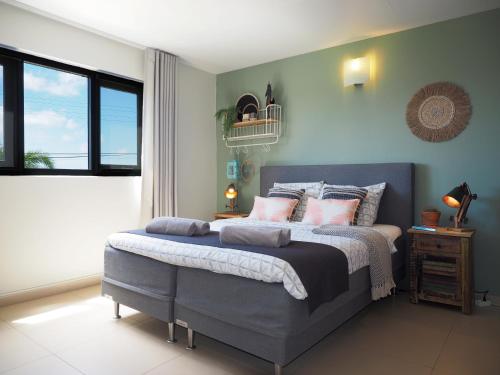 a bedroom with a large bed with pink pillows at Oasis guesthouse, Boutique Style Hotel in Kralendijk