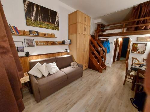 ein Wohnzimmer mit einem Sofa und Holzböden in der Unterkunft Le Petit Refuge Cervinia in Breuil-Cervinia