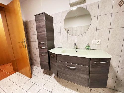 uma casa de banho com um lavatório e um espelho em Frog’s Palace 3 em Altach