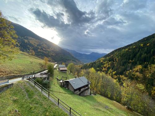 una casa en una colina en un valle con montañas en Baita Valtellina. Relax nel cuore delle Alpi, en Grosio