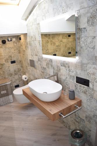 a bathroom with a large white sink and a mirror at Baita Valtellina. Relax nel cuore delle Alpi in Grosio