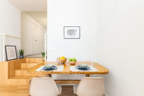 a dining room with a wooden table and chairs at Welcome Aliados a Noble apartment in City Heart in Porto