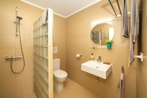 a bathroom with a sink and a toilet and a mirror at Oasis guesthouse, Boutique Style Hotel in Kralendijk