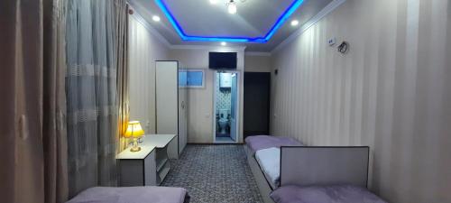 a hospital room with two beds and a blue light at Hotel Zarafshon in Panjakent