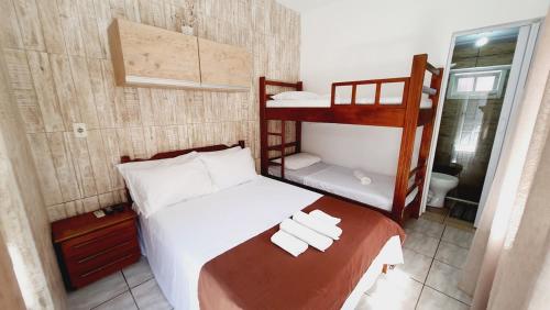 a bedroom with a bed with two bunk beds at Open House Canasvieiras - OH HOTÉIS in Florianópolis