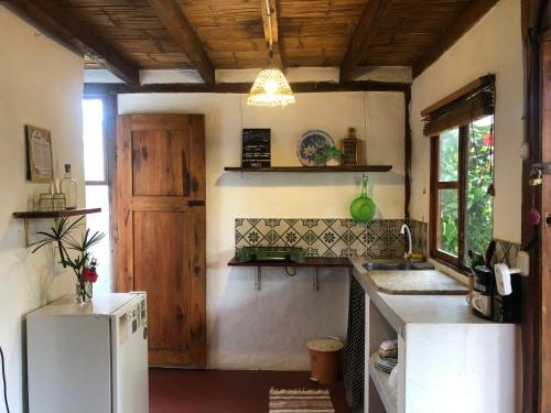 a kitchen with a white refrigerator and a wooden ceiling at Hostal Los Orishas in Ayampe