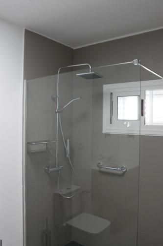 een badkamer met een douche en een glazen deur bij Rooms & Suites Princesa Leticia in Puerto del Carmen