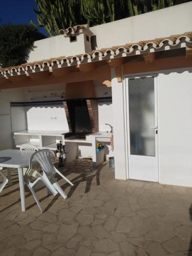 a patio with a table and chairs in front of a house at CASA CARMEN in Calpe