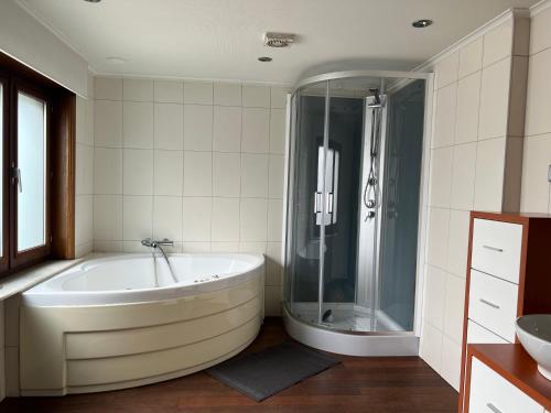 a white bathroom with a tub and a shower at Appartement29 in Wetteren