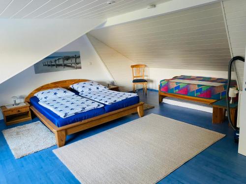 - une chambre avec deux lits et une chaise dans l'établissement Ferienhaus an der Küste im Luftkurort Hage, à Hage
