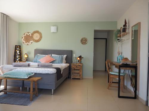 a bedroom with a bed and a table and a desk at Oasis guesthouse, Boutique Style Hotel in Kralendijk