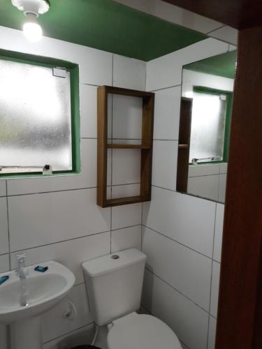 bagno con servizi igienici, lavandino e specchio di Jardim da Lagoa Casas de aluguel de temporada a Garopaba